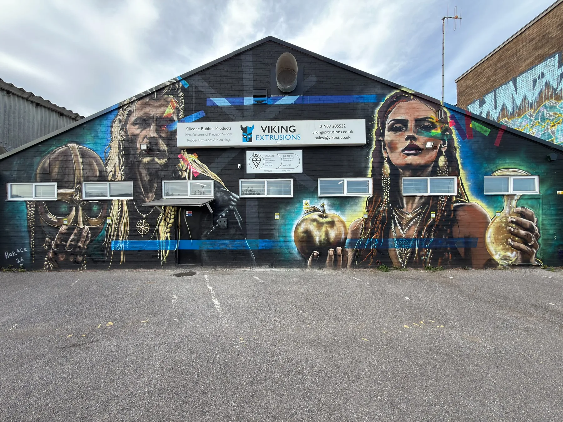 Mural of two Viking figures painted across the rear of the Viking Extrusions building, overlooking the railway line at Ivy Arch Road, Worthing